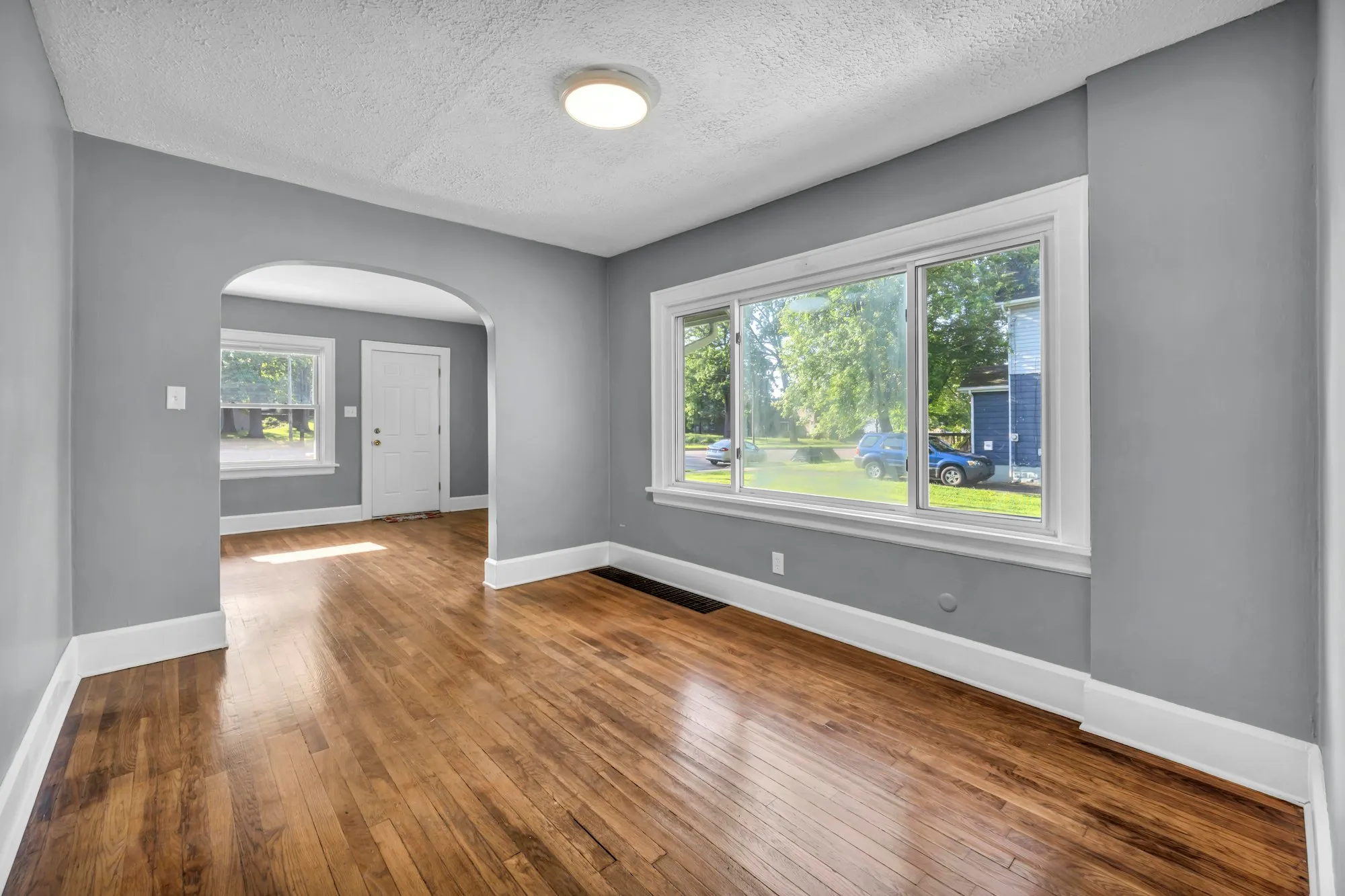 Refinished hardwood floor in a bright, empty room