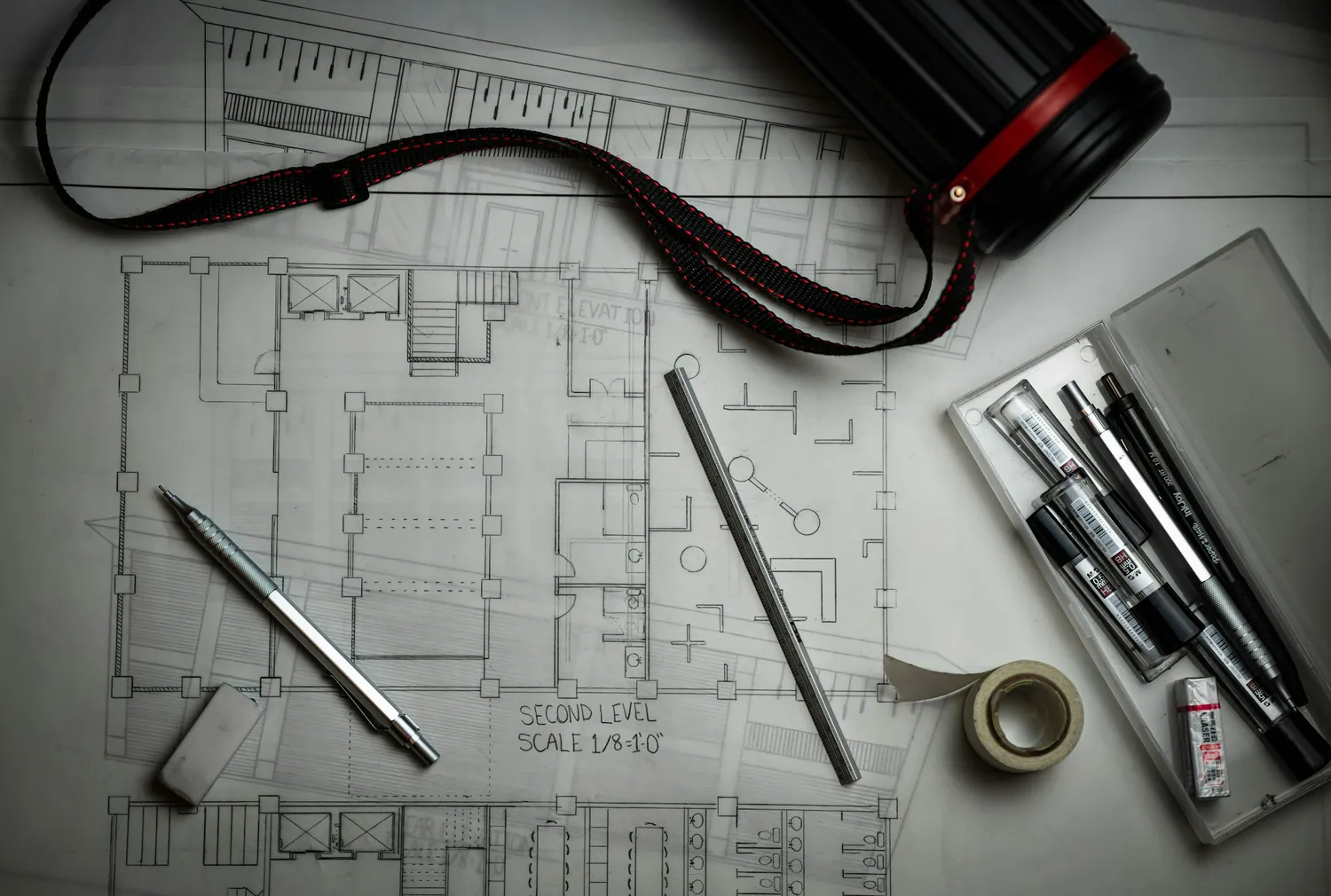 Floor plan drawings laid out with pencils and a scale ruler