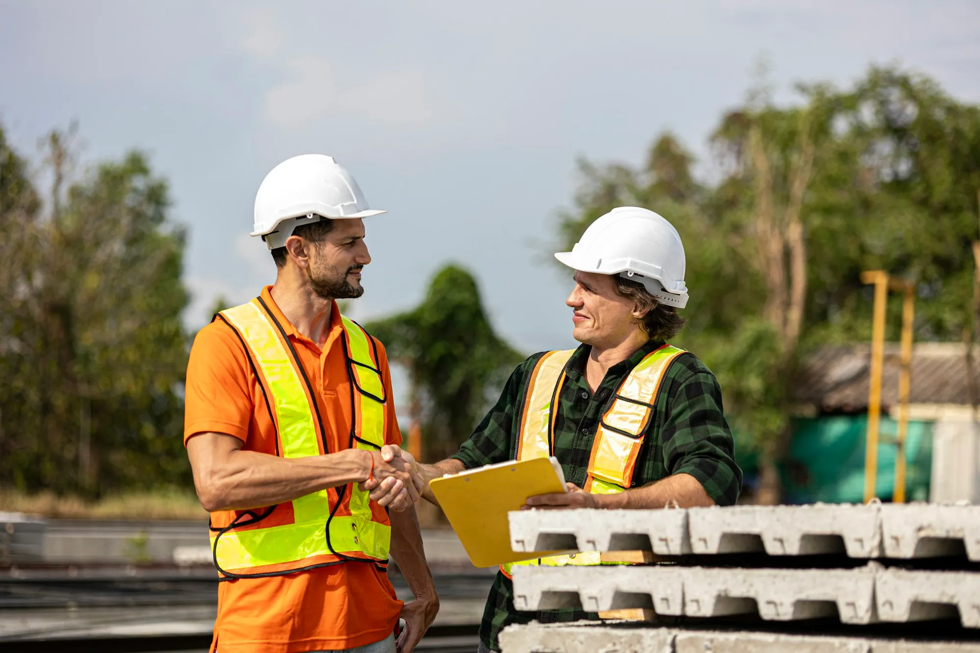 Two workers shaking hands on a job site