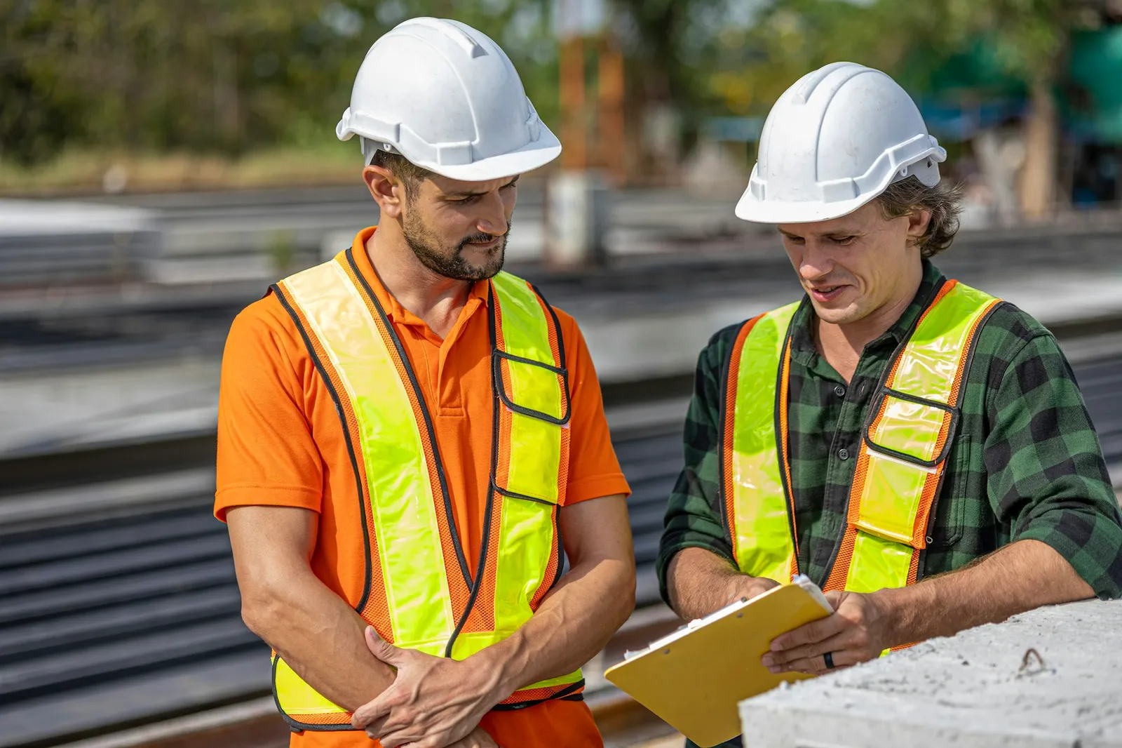 Two workers checking drawings against the work on a job site