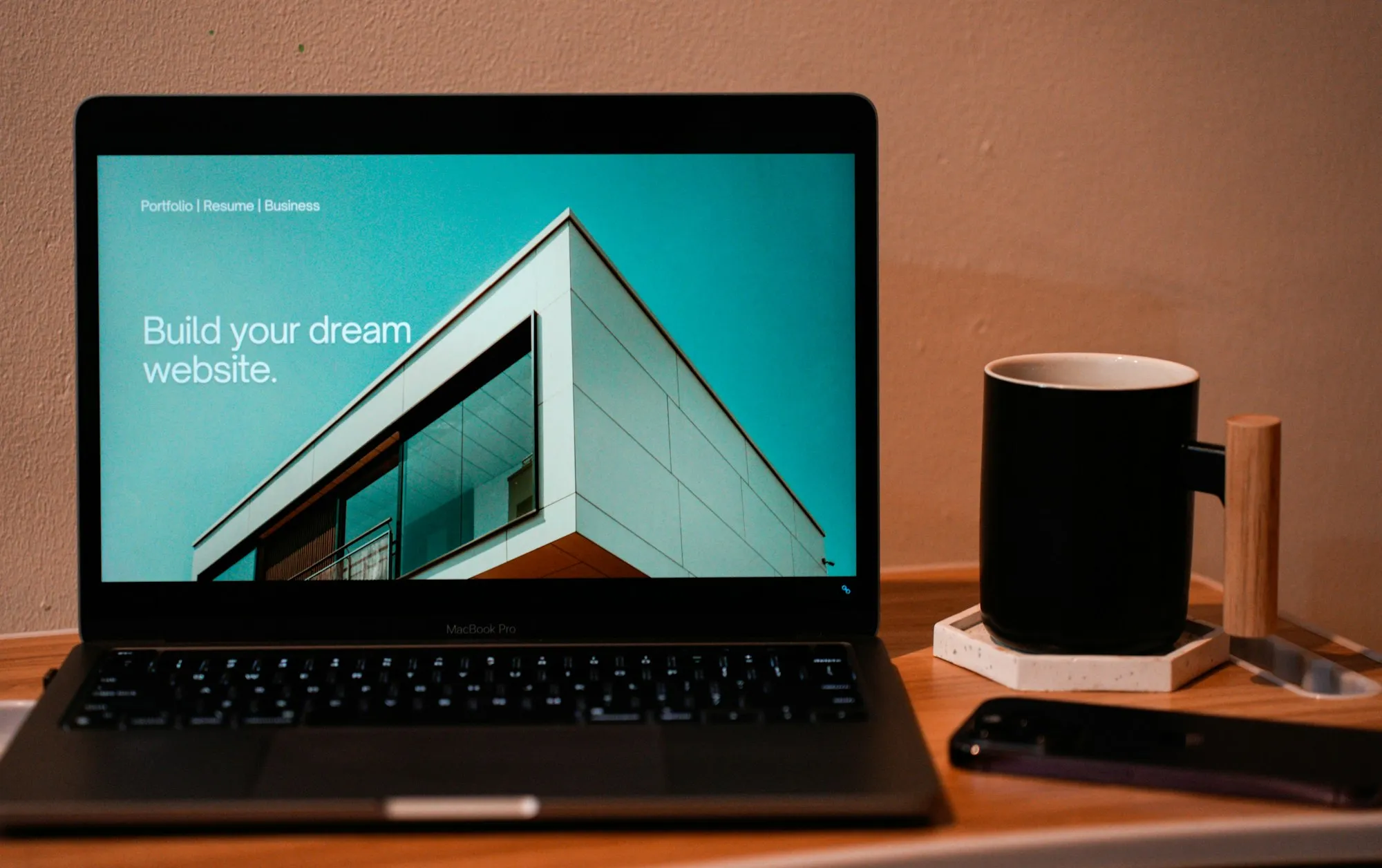 A laptop on a desk showing a website homepage