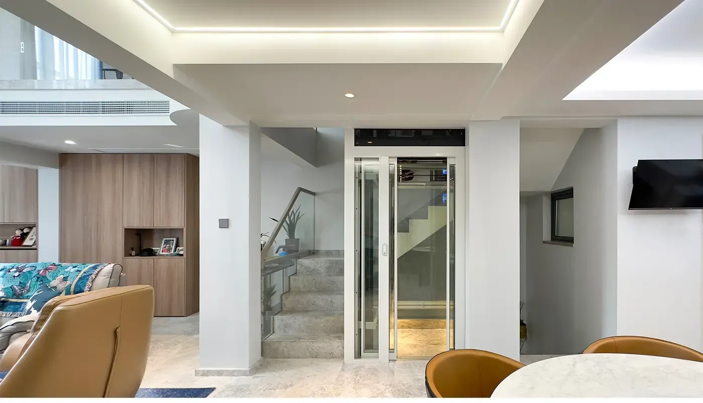 White-framed glass home elevator beside a staircase